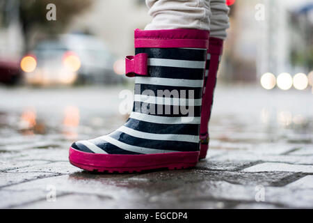 Kleines Mädchen im Regen tragen süße Gummistiefel Stockfoto