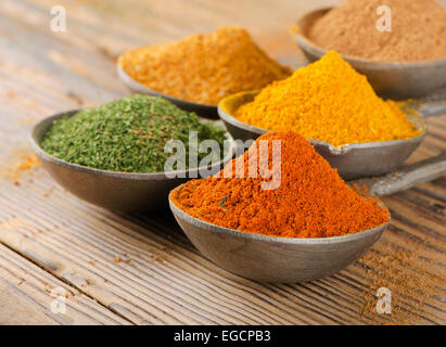 Gewürze auf Löffeln auf einem hölzernen Hintergrund. Stockfoto