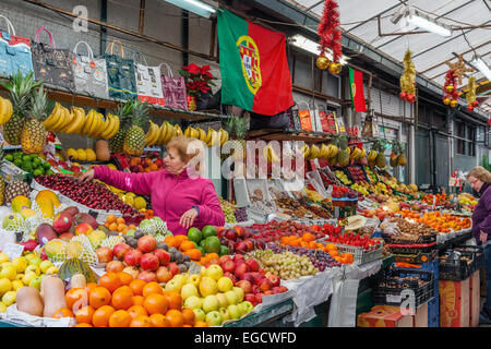 Porto, Portugal. Obst-Verkäufer organisiert und kümmert sich um den Stand in das Innere des historischen Bolhao Markt Stockfoto