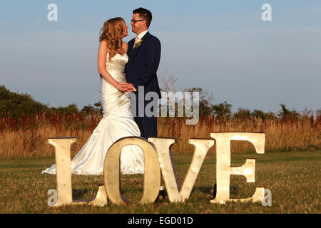 Charlotte und Chris abgebildet mit Liebe auf ihre Hochzeit in Southend Scheunen in Chichester, West Sussex, UK. Stockfoto