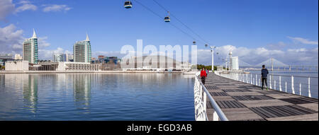 Menschen am Passeio Ribeirinho, Parque Das Nacoes, Lissabon, Portugal. Atlantico Pavilion, MEO Arena. Vasco da Gama Tower und Brücke, unzähligen Hotels Stockfoto