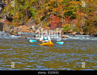 Ein Baby-Boomer im Alter Mann in einem Kajak an einer ruhigen Stelle im Fluss. Stockfoto