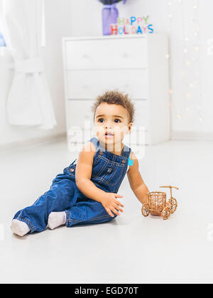 Babymädchen sitzen auf weißem Hintergrund mit Spielzeug spielen Stockfoto