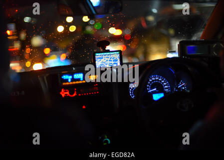 Armaturenbrett eines Taxis im Nachtverkehr, Jakarta. Stockfoto