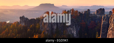 Das erste Sonnenlicht trifft der Bastei-Brücke und den Berggipfeln des Elbe Sandstein-Massivs im Herbst, Sächsische Schweiz, Sachsen, Deutschland Stockfoto