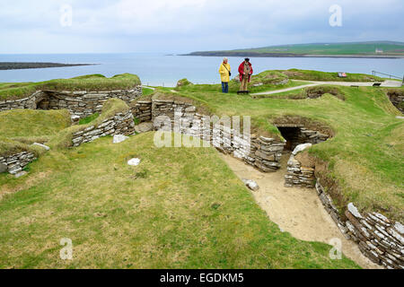 Zwei Touristen in der neolithischen Siedlung Skara Brae, Site Skara Brae, UNESCO-Welterbe Herzen der neolithischen Orkney, Orkney Inseln, Schottland, Großbritannien, Vereinigtes Königreich Stockfoto