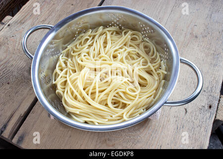 Frisch gekochte Spaghetti in Sieb auf Holztisch Stockfoto