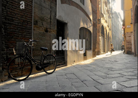 Fahrrad in einer engen Gasse im Morgenlicht in Lucca, Toskana, Italien Stockfoto