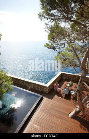 Gäste auf dem Deck in der Nähe von Cliff Pool, Aman Sveti Stefan, Sveti Stefan, Budva, Montenegro Stockfoto