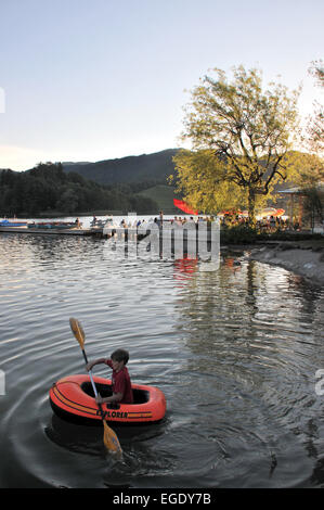 Junge in einem Paddelboot nahe dem Bootsverleih und Café in Schliersee, Schliersee See, Bayern, Deutschland Stockfoto