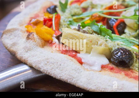 Teil einer traditionellen italienischen Pizza mit Artischocken, Tomaten und Oliven Stockfoto