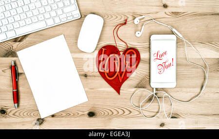 Büro-Arbeitsplatz mit roten Herzen, Tastatur, Tablet-PC, Telefon. Valentinstag-Konzept. Beispieltext Love You! Stockfoto