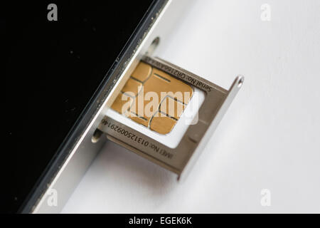 Eine micro SIM-Karte wird in ein Apple Iphone 4 Smartphone eingefügt. Stockfoto