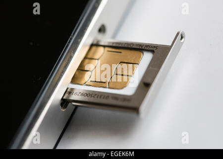 Eine micro SIM-Karte wird in ein Apple Iphone 4 Smartphone eingefügt. Stockfoto