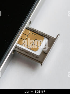 Eine micro SIM-Karte wird in ein Apple Iphone 4 Smartphone eingefügt. Stockfoto