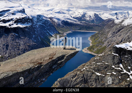 Backpacker auf der sonnenbeschienenen Trolltunga Felsen, Norwegen Stockfoto