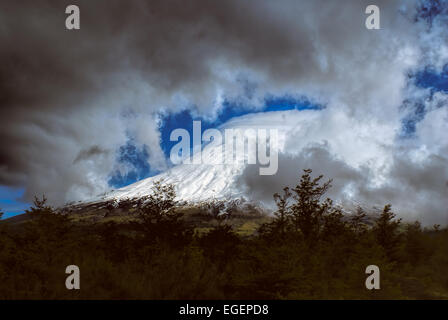 Atemberaubenden Blick auf die grauen Wolken überrollen Berggipfel im Parque Nacional Vicente Pérez Rosales Stockfoto