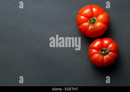 die roten Tomaten auf schwarzem Hintergrund Stockfoto