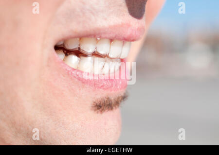 Nahaufnahme von der Mündung eines jungen Mannes, der klare Aufbewahrungen trägt Stockfoto