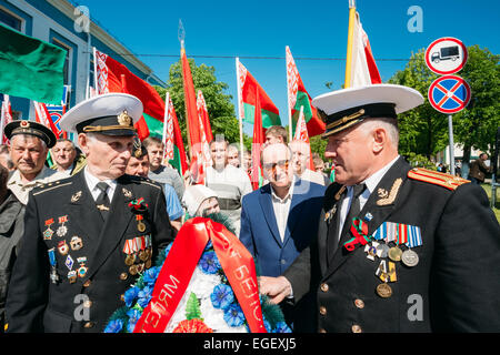 Dobrush (Region Gomel), BELARUS - 9. Mai 2014: Unidentified belarussischen Veteranen auf der Parade halten Kränze und Flaggen des G Stockfoto