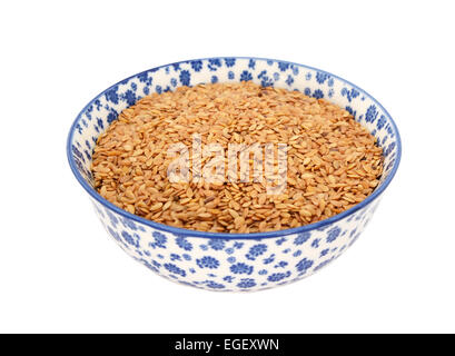 Goldenen Leinsamen oder Leinsamen in einer blau-weißen Porzellanschüssel mit floralem Design, isoliert auf weißem Hintergrund Stockfoto