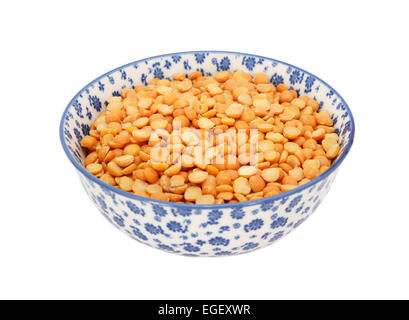Gelbe Erbsen in einer blau-weißen Porzellanschüssel mit floralem Design, isoliert auf weißem Hintergrund Stockfoto