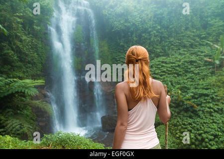 Weibliche Abenteurer am Wasserfall im Dschungel Bali suchen Stockfoto