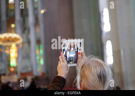 Frau Fotos Videos Innere der Sagrada Familia, Barcelona, mit einem Tablet iPad Art Gerät. Welt erleben Digital Stockfoto