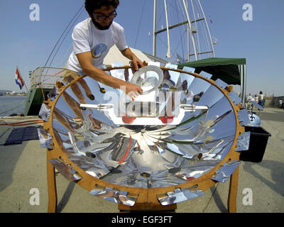 Ein Mitglied der Crew kocht einige Lebensmittel an Bord Greenpeace Rainbow Warrior mit einem solar betriebenen Gerät. Das Schiff, das in Bulgarien am Dienstagabend (19 Aug 14) angekommen, ist derzeit auf Europa-Tournee in 10 Ländern, während die Greenpeace p wird, Einschiffung Stockfoto