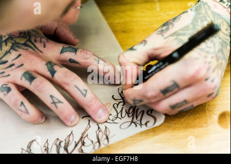 Ein Tätowierer, ein Design auf der Brighton-Tattoo-Convention arbeiten. Stockfoto