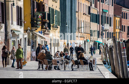 Einheimische und Touristen genießen das warme Wetter, das Essen im Freien im Stadtteil Cannaregio in Venedig an einem schönen sonnigen Tag Stockfoto