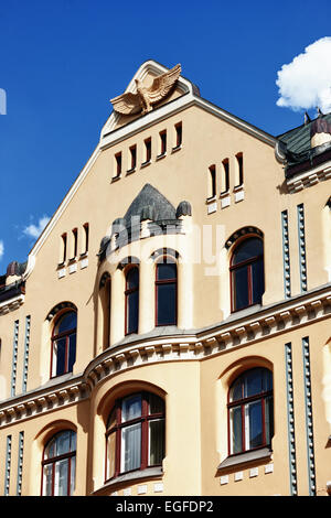 Gelbe Vintage Katzenhaus mit einem Flachrelief eines Adlers auf einem Hintergrund des blauen Himmels in der Altstadt. Vecriga Riga. Lettland Stockfoto