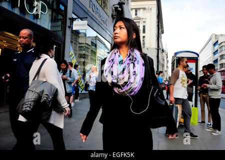 London, England, Vereinigtes Königreich. Junge Asiatin mit Kopfhörern in der Oxford Street Stockfoto