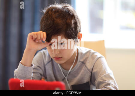 Schwere Jungen spielen mit Tablet-PC Stockfoto