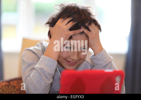 Erbittert junge spielt mit Tablet-PC Stockfoto