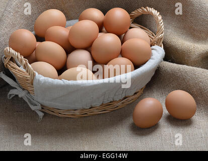 viele der Hühnereier in einem Korb auf Sackleinen Hintergrund Stockfoto