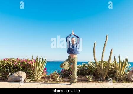 Frau tut Yoga Asana in Sea resort Stockfoto