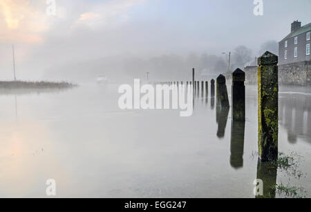 Laugharne, Herbst Flut an einem nebligen Morgen, überflutete Gebiet und Bahn mit einem kleinen Boot in der Ferne Stockfoto