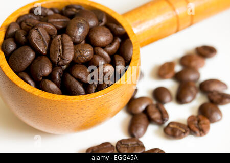 Kaffeebohnen in Kochlöffel auf weißem Hintergrund Stockfoto