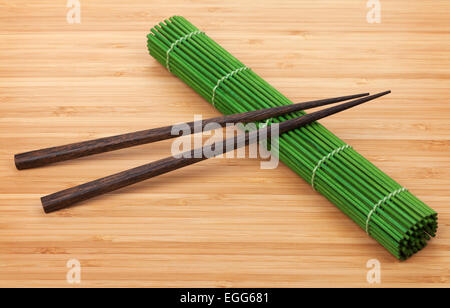 Ess-Stäbchen und Bambusmatte auf Tisch Stockfoto