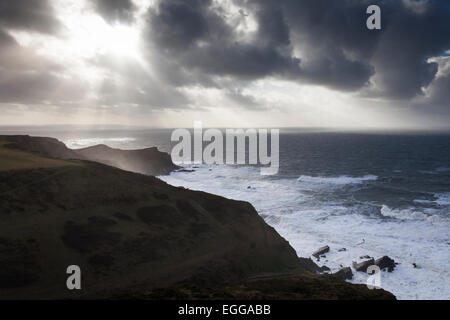 Sonnenlicht durch graue Gewitterwolken, Blick aufs Meer von der Küste Weg, 'Pfarrhaus Cliff', Morwenstow, Cornwall, England, UK Stockfoto