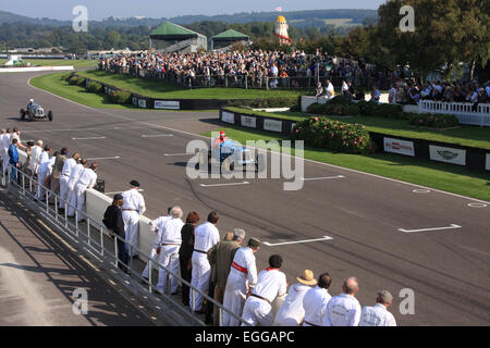 Boxencrew säumen die Strecke in der Sonne wie Ludovic Lindsay in seinem blauen 1936 ERA B-Typ R5B "Remus" nähert sich / Goodwood Revival Stockfoto