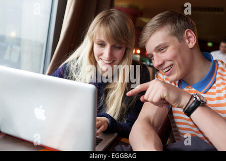 16 Jahre alten Jungen und Mädchen, die Spaß am Laptop. Stockfoto