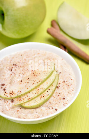 Haferflocken-Porridge mit Apfelstückchen und Zimt in einer Schüssel weiß Stockfoto