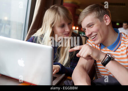 16 Jahre alten Jungen und Mädchen, die Spaß am Laptop. Stockfoto