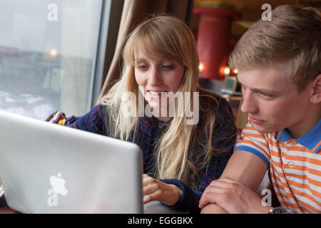 16 Jahre alten Jungen und Mädchen, die Spaß am Laptop. Stockfoto