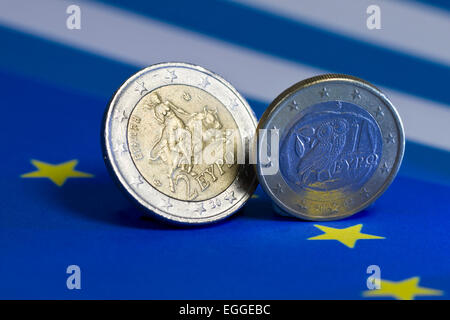 ein bis zwei Euro-Münzen aus Griechenland auf Fahnen Stockfoto