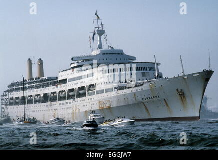 AJAXNETPHOTO. 11TH. JULI 1982. SOUTHAMPTON, ENGLAND. - WAL KEHRT ZURÜCK - S.S.CANBERRA, DIE VON DER MOD ALS ATROOPSHIP WÄHREND DES FALKLANDKONFLIKTS EINGESETZT WURDE, KEHRT NACH SOUTHAMPTON ZURÜCK, BEGLEITET VON EINER RIESIGEN FLOTTE VON BRUNNENFISCHERN. FOTO: JONATHAN EASTLAND/AJAX. REF:91018 1 Stockfoto