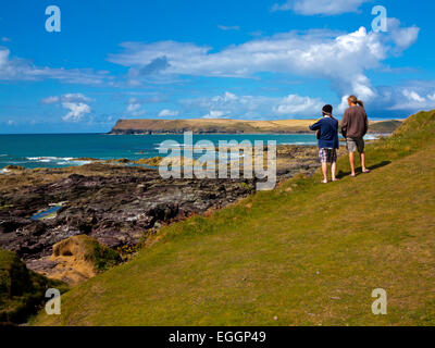 TTWO Menschen betrachten von Daymer Bay in Richtung Trebetherick Point an der Küste von North Cornwall im Südwesten England UK Stockfoto