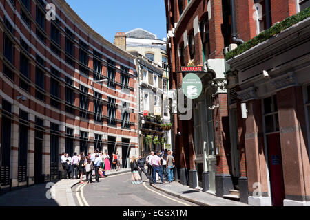 Menschen trinken außerhalb von Kneipen und Bars am St Andrew Hill, London, England Stockfoto